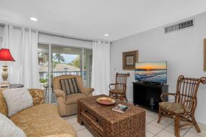 a living room with a couch and a tv at Coastal Paradise 815 in Naples