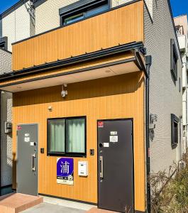 un edificio con dos puertas y una señal en él en HANASTAY花渓居 · 浦（URA), en Osaka