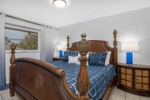 a bedroom with a bed with a blue comforter at Coastal Paradise 815 in Naples