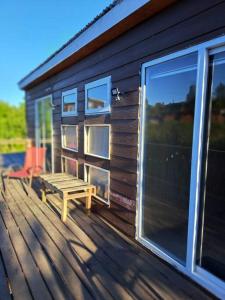 una terraza de madera con un banco y una casa en Cabaña cerca del Aeropuerto en Puerto Montt