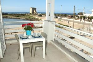 トッレ・ラピッロにあるAltomare Case Vacanzaの海の景色を望むバルコニー(花のテーブル付)