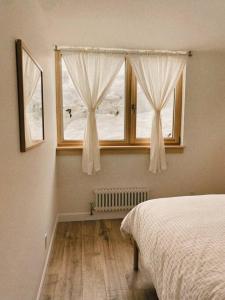 1 dormitorio con cama y ventana en The Burrow - Downtown Revelstoke, en Revelstoke