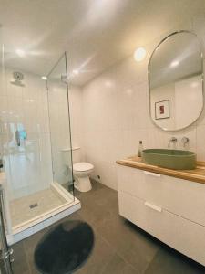 a bathroom with a shower and a sink and a toilet at The Burrow - Downtown Revelstoke in Revelstoke