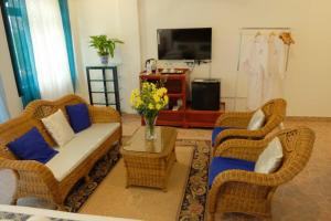 sala de estar con 2 sillas de mimbre y sofá en Villa Italia Hotel en Sorsogon