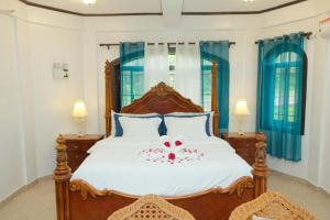 a bedroom with a large bed with a red bow on it at Villa Italia Hotel in Sorsogon