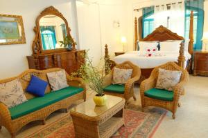 1 dormitorio con 1 cama con sillas de mimbre y mesa en Villa Italia Hotel en Sorsogon