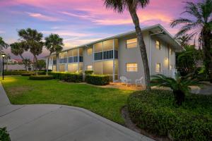 a building with palm trees in front of it at Sandy Waves 817 in Naples