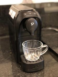 a coffee maker with a measuring cup on a counter at Monte Fuji ~ GRU 39m2 in Guarulhos