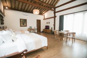 a bedroom with a bed and a table and chairs at LAYANA FARMSTAY in Banyuwangi