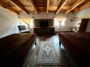 1 dormitorio con 2 camas, sofá y TV en Hotel San Sebastian en Valle de Bravo