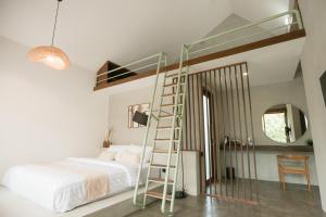 a bedroom with a bunk bed and a ladder at LAYANA FARMSTAY in Banyuwangi
