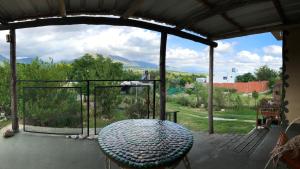 a screened in porch with a table and a view at Hosteria Dharma in Capilla del Monte