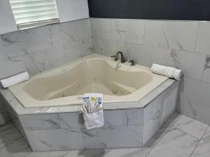 y baño con bañera blanca y azulejos blancos. en Goldstar Inn en Los Ángeles