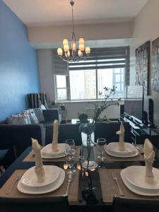 a dining room table with plates and glasses on it at Suites de Marina Manila with Netflix in Manila