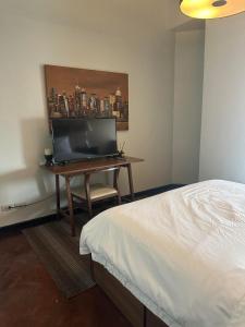 a bedroom with a bed and a desk with a flat screen tv at Suites de Marina Manila with Netflix in Manila