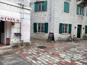 a building with green shutters and a sign in front of it at Apartments Đukić in Kotor