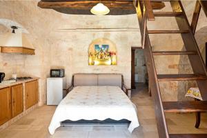 um quarto com uma cama e uma escada em espiral em Giardini della Canonica Alberobello em Martina Franca