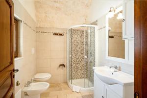 uma casa de banho com um chuveiro, um WC e um lavatório. em Giardini della Canonica Alberobello em Martina Franca