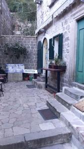 a stone courtyard with a bench and a building at Apartments Đukić in Kotor