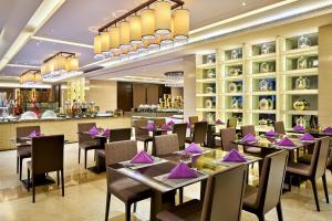 un restaurante con mesas y sillas con servilletas moradas en Crowne Plaza Tianjin Jinnan, an IHG Hotel en Tianjin