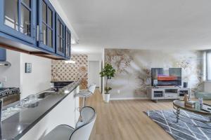 a living room with a kitchen and a tv at 5 STAR APT in Towson