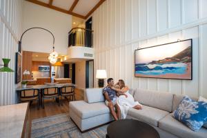 a bride and groom sitting on a couch in a living room at The Villas at Fairmont Kea Lani in Wailea