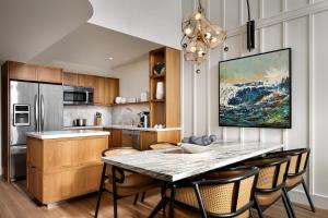 a kitchen with a table with chairs and a painting on the wall at The Villas at Fairmont Kea Lani in Wailea