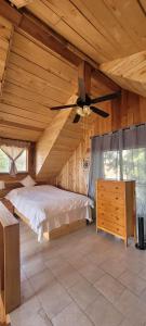 a bedroom with a bed and a ceiling fan at Rustic cedar Cabin in Powell River