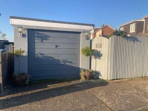 una puerta de garaje azul al lado de una valla en Scott’s lodge, en Kent
