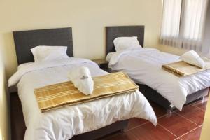 2 camas con toallas en una habitación en Chuklla, en Yanque