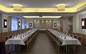 un salón de banquetes con filas de mesas y sillas en Hotel Restaurant Wallner I contactless check-in, en Sankt Valentin