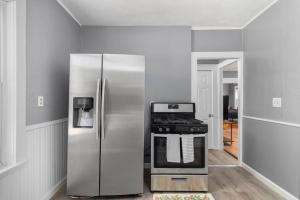 Il comprend une cuisine équipée d'un réfrigérateur en acier inoxydable et d'une cuisinière. dans l'établissement Modern 2 Bedroom in Downtown Providence., à Providence