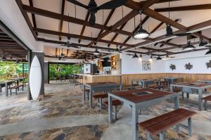 タモンにあるDusit Beach Resort Guamのテーブルと椅子とカウンターのあるレストラン