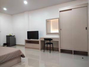 1 dormitorio con 1 cama y escritorio con TV en HADA House Service Apartment en Bangkok
