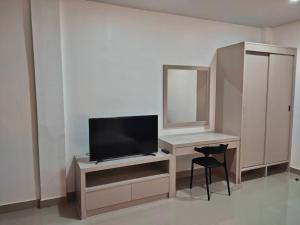 曼谷的住宿－HADA House Service Apartment，客房设有一张带电视和镜子的书桌