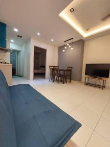 a living room with a blue rug and a television at Rest And Go Homestay in Shah Alam
