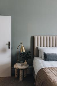 a bedroom with a bed and a lamp on a table at Mittagong Hotel in Mittagong