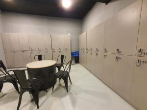 a locker room with chairs and a table and cabinets at My Capsule Hotel in Johor Bahru