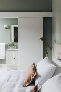 a bedroom with a white bed and a mirror at Mittagong Hotel in Mittagong