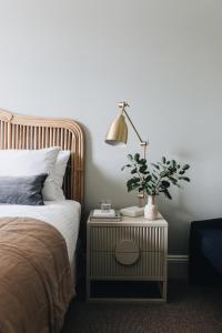 a bedroom with a bed and a lamp on a night stand at Mittagong Hotel in Mittagong
