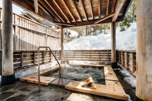 a hot tub in a wooden structure with snow at Apikogen Mori no Hotel in Hachimantai