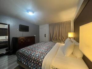 Habitación de hotel con cama y TV en Goldstar Inn en Los Ángeles