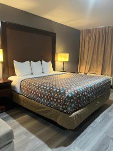 a large bed in a hotel room with two lamps at Goldstar Inn in Los Angeles