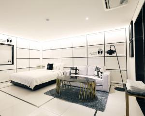 Mari Hotel في تشونغجو: غرفة نوم بسرير وطاولة واريكة