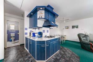 a kitchen with blue cabinets and a green floor at House and Apt in Balatonboglar 42692 in Balatonboglár