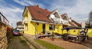 a yellow house with a picnic table in the yard at House and Apt in Balatonboglar 42692 in Balatonboglár