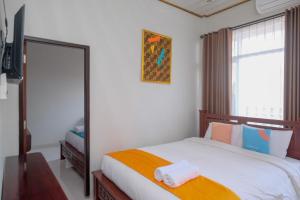 sypialnia z łóżkiem z lustrem i oknem w obiekcie Sans Hotel Kumbang Yogyakarta by RedDoorz w mieście Yogyakarta