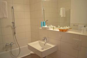 bagno bianco con lavandino e doccia di Houses and Apts in Sassenburg Niedersachsen 42038 a Sassenburg