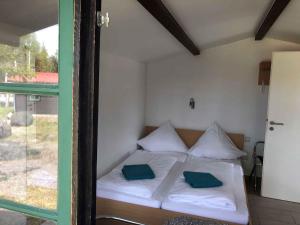 una camera da letto con un letto con due cuscini verdi di Houses and Apts in Sassenburg Niedersachsen 42038 a Sassenburg