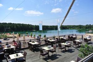 um restaurante com mesas e cadeiras e vista para um rio em Houses and Apts in Sassenburg Niedersachsen 42038 em Sassenburg